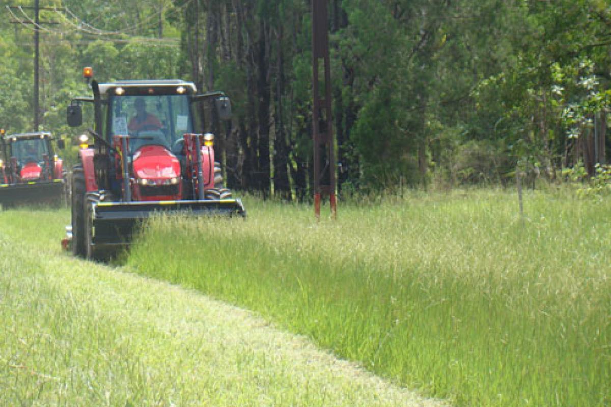 Tractor clearing long grass